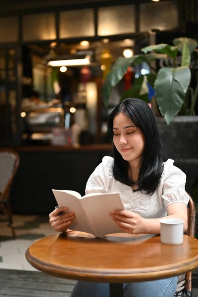 Retrato Atraente Jovem Asiática Lendo Livro Enquanto Relaxa Bela Cafeteria — Fotografia de Stock