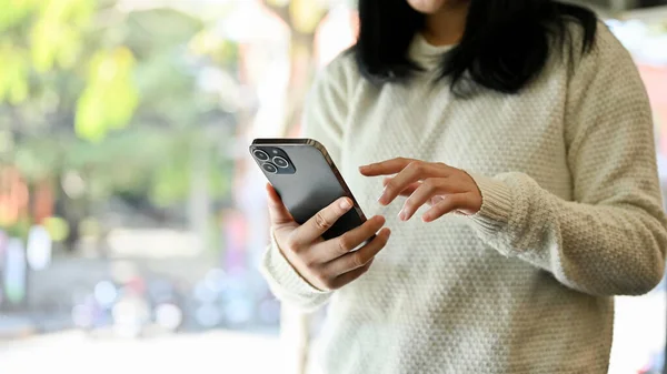 Beyaz Kazaklı Asyalı Bir Kadın Elinde Cep Telefonu Akıllı Telefonunu — Stok fotoğraf