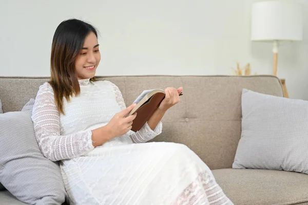 漂亮的亚洲孕妇坐在沙发上 放松下来 在客厅看书 母性活动和生活方式概念 — 图库照片