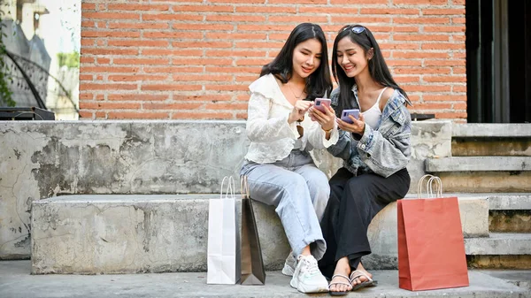 Twee Gelukkige Aantrekkelijke Jonge Aziatische Vrouw Met Hun Boodschappentassen Zittend — Stockfoto