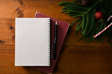 Üst Manzara, Flay lay lay boş defter sayfa ve kalem ahşap masa üzerinde noel süsleri ve bitki.