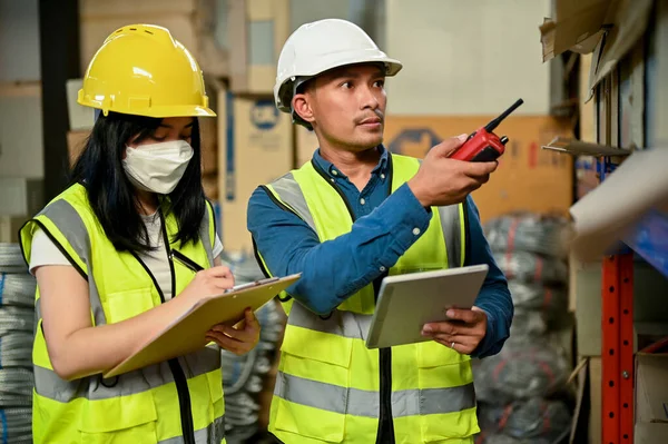 新しい女性労働者を訓練し 倉庫や倉庫に在庫をチェックするプロの大人のアジアの男性倉庫監督者 — ストック写真