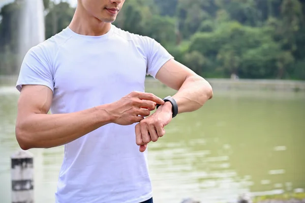 Knappe Atletische Jonge Aziatische Man Sportkleding Kijkt Naar Zijn Smartwatch — Stockfoto