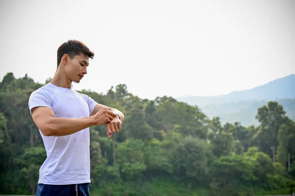 Спортивный Молодой Азиатский Спортсмен Спортивной Одежде Проверяет Пробежки Своих Умных — стоковое фото