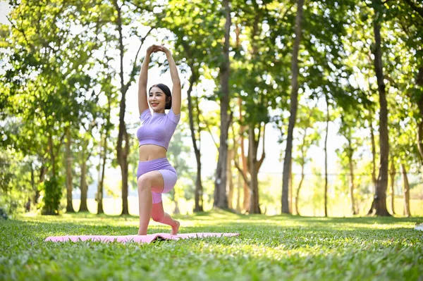 健康快乐的千年女性 穿着运动服 练习瑜伽 做我所扮演的战士 在花园里锻炼 — 图库照片