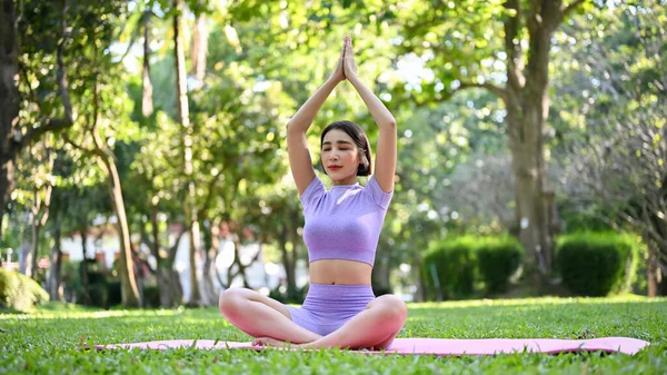 在绿色的自然花园里 身着运动服练习坐着的鹰姿势 冥想和训练瑜伽的亚洲妇女平静而轻松 — 图库照片