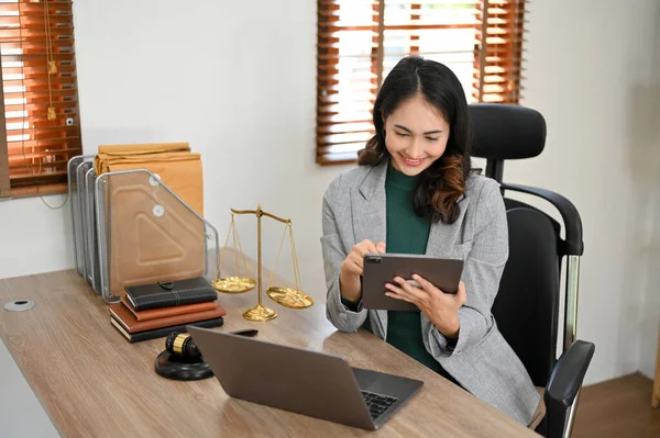 千年一次的亚洲女专业律师或商业法律顾问在现代办公室的办公桌前使用数码平板电脑 — 图库照片