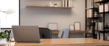 Çalışma odasındaki minimalist parlak ofis masasında laptoplu bilgisayar, dekor ve ofis arka planında bulanık duran ahşap masa üzerindeki kopyalama alanı. 3d görüntüleme, 3d illüstrasyon