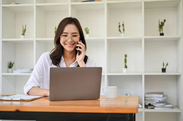 Gyönyörű Boldog Millenniumi Ázsiai Üzletasszony Vagy Női Asszisztens Asztalánál Telefonon — Stock Fotó