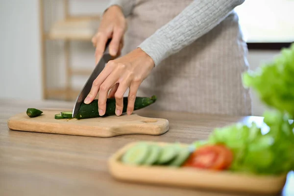 クローズアップ手のイメージ キッチンで美しい女性や妻の料理 キュウリをスライドさせる調理ナイフを使用して サラダボウルを作る — ストック写真