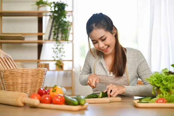 幸せと魅力的な若いアジアの女性はキュウリを切断し キッチンで彼女の健康的なサラダボウルを作ります 幸福と健康的なライフスタイル — ストック写真