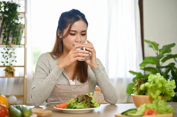 健康的な千年紀のアジアの女性は 彼女の健康的な朝食を食べる前に 台所で水を飲み 飲みます — ストック写真