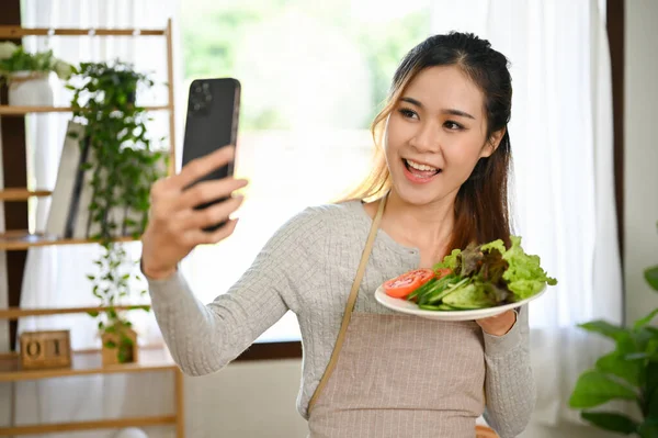 迷人迷人的年轻亚洲女性或家庭主妇用她的智能手机在厨房里给自己和她自制的沙拉拍照 健康生活方式概念 — 图库照片