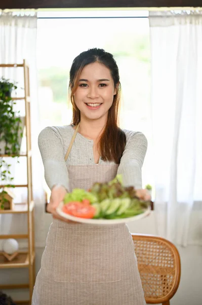 肖像画 美しい若いアジアの女性は 新鮮な有機グリーンサラダのプレートを保持し エプロンを着て 健康食品とライフスタイルのコンセプト — ストック写真