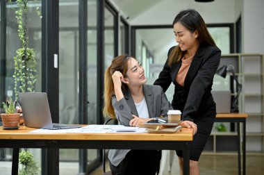 Ofiste birlikte çalışan iki çekici ve güzel Asyalı iş kadını. Takım çalışması ve iş adamı konsepti