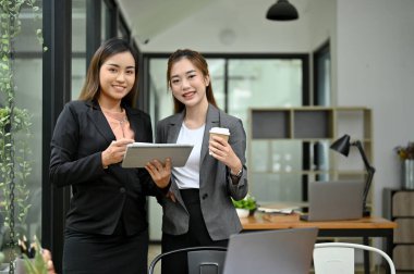 Ofiste birlikte duran iki profesyonel ve başarılı Asyalı iş kadını. İş insanları kavramı