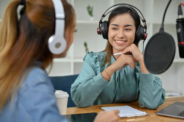 Profesyonel Asyalı kadın podcaster ya da radyo sunucusu özel konuğu ile stüdyoda röportaj yapmaktan hoşlanıyor. Yayın ya da podcaster konsepti