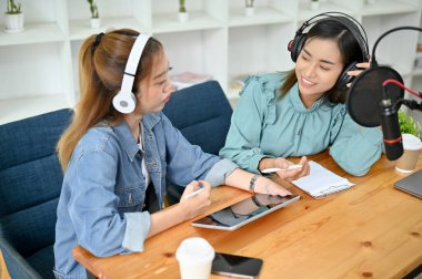 İki profesyonel ve çekici Asyalı bayan radyo sunucusu veya podcaster gösterisini stüdyoda yürütüyor, çevrimiçi seyircilerine ilginç bir konu anlatıyor..