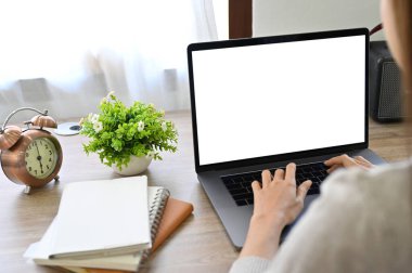 Dizüstü bilgisayar kullanan bir iş kadını ya da kadın serbest yazar, klavyeye yazar, iş işlerini yönetir, dizüstü bilgisayarının beyaz ekran modelini yapar. arka plan