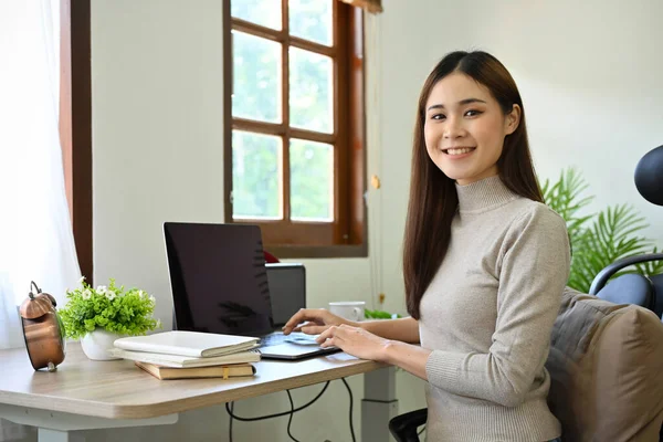 迷人而成功的年轻亚洲女商人或穿着休闲装的女营销经理坐在写字台前 微笑着看着镜头 — 图库照片