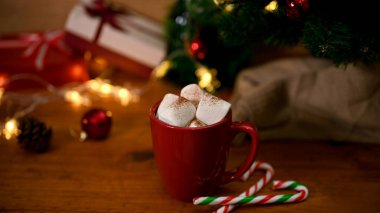 Bir fincan sıcak çikolata, ahşap masada eritilmiş marşmelov Noel ağacı ve dekorla. Geleneksel Noel içkisi. Mutlu Noeller.