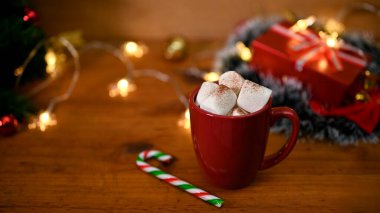 Tahta masa üzerinde noel süsüsüyle marşmelovlu bir fincan lezzetli sıcak çikolata. Geleneksel Noel içkisi. yakın plan resim