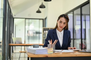 Profesyonel Asyalı iş kadını ya da resmi takım elbiseli bayan yönetici ofisinde masasında çalışıyor..