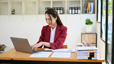 Profesyonel ve başarılı Asyalı iş kadını ofiste çalışıyor, dizüstü bilgisayar kullanıyor, iş işlerini yönetiyor..