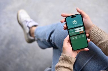 Chiang Mai, Tayland - 25 Kasım 2022: Çevrimiçi bankacılık başvuru formunun yazılı olduğu akıllı telefonu tutan ya da ekranda oturum açan bir kadın. Mobil bankacılık, para transferi