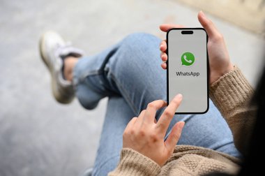 Chiang Mai, Tayland - 25 Kasım 2022: WhatsApp uygulama logosu olan akıllı telefonu elinde tutan bir kadın. en üstteki görünüm