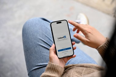 Chiang Mai, Tayland - 25 Kasım 2022 Linkedin uygulama logosu olan akıllı telefonu elinde tutan bir kadın. İş, kariyer, staj, işe alım.
