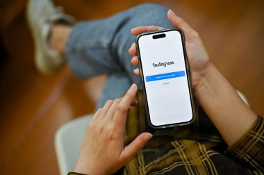 Chiang Mai, Tayland - 24 Kasım 2022: Instagram logosu olan akıllı telefonu kullanan bir kadın. çevrimiçi sosyal medya platformu