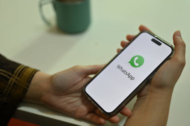 Chiang Mai, Tayland - 24 Kasım 2022: Beyaz WhatsApp logosunu tutan bir kadın el. mobil sohbet uygulaması. yakın plan resim