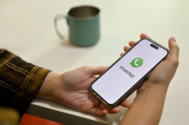 Chiang Mai, Tayland - 24 Kasım 2022: Beyaz WhatsApp logosunu tutan bir kadın el. Sohbet, mesaj, mesaj..