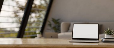 Çalışma alanı masaüstü dizüstü bilgisayarlı boş ekran modeliyle grafik, kitap, dekor bitki ve bulanık oturma odası arkaplanını kopyalamak için. 3d görüntüleme, 3d illüstrasyon