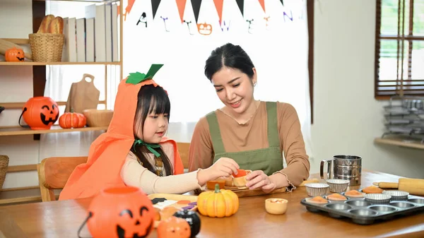 美丽的亚洲妈妈和她可爱的女儿在家里一起烘焙万圣节南瓜蛋糕 万圣节活动概念 — 图库照片