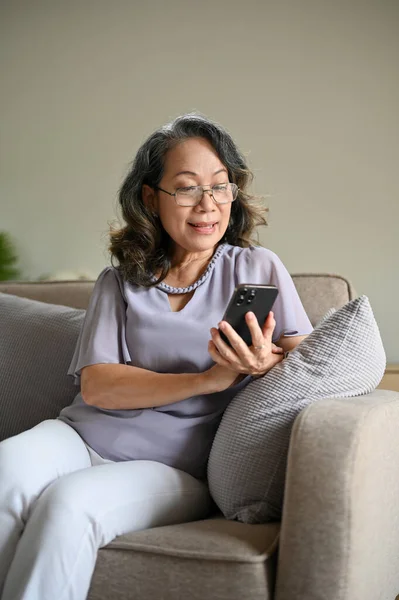 Portrét Krásná Stárnoucí Asijská Žena Nosí Brýle Sedí Pohodlném Gauči — Stock fotografie