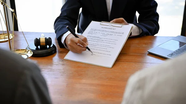A male lawyer or business legal consultant showing and explaining the legal contract agreement paper to his clients. close-up image