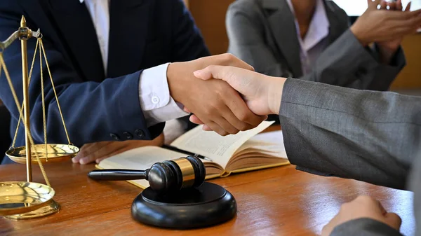A businessman shakes hands with his lawyer after winning a lawsuit. cropped and close-up hands image
