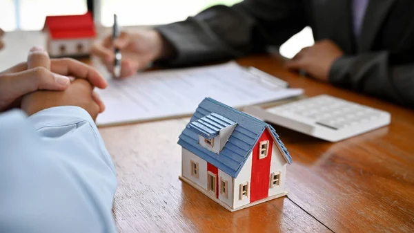 stock image A male client meets with a professional female real estate broker or realtor to finalize a business transaction. cropped image