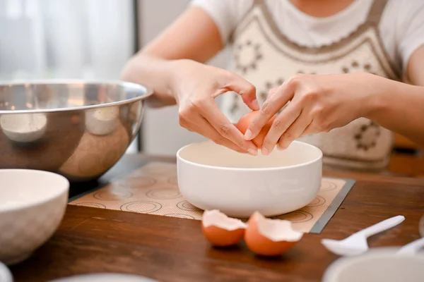 女性は卵を割り 卵黄を卵白から分離し 台所でカップケーキの成分を調製する カップケーキか甘いレシピ クローズアップ画像 — ストック写真