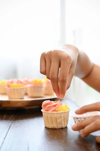 クローズアップ画像 彼女の家でカップケーキを作るプロの女性パン屋 スプリンクルで彼女の新鮮なカップケーキを飾る — ストック写真