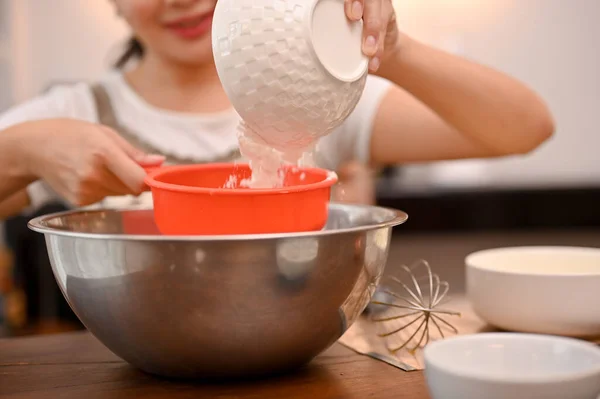 魅力的な若いアジアの女性は彼女の台所でカップケーキを焼き 小麦粉のふるい機で彼女のカップケーキの小麦粉を準備しています カップケーキのレシピのコンセプト クローズアップ画像 — ストック写真
