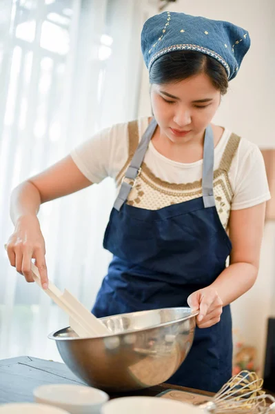 ポートレート キッチンでカップケーキの粉を準備かなり若いアジアの女性パン屋 混合ボウルに混合物を混ぜる カップケーキのレシピコンセプト — ストック写真