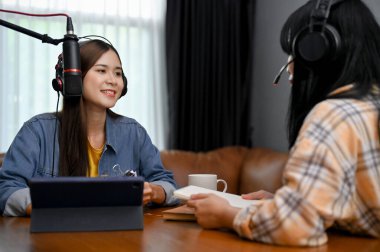 Çekici ve yetenekli Asyalı kadın özel konuğu ile stüdyoda röportaj yapmaktan hoşlanıyor. Podcast veya çevrimiçi radyo programı konsepti