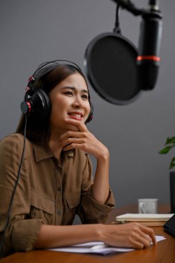 Portre, güzel ve yetenekli Asyalı bayan radyo sunucusu veya podcaster gösterisini evindeki profesyonel stüdyosunda yapıyor..