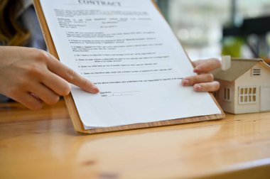 Yakın plan görüntü, emlak yatırım sözleşmesi belgelerini gösteren bir emlakçı, anlaşmayı imzalamak için..