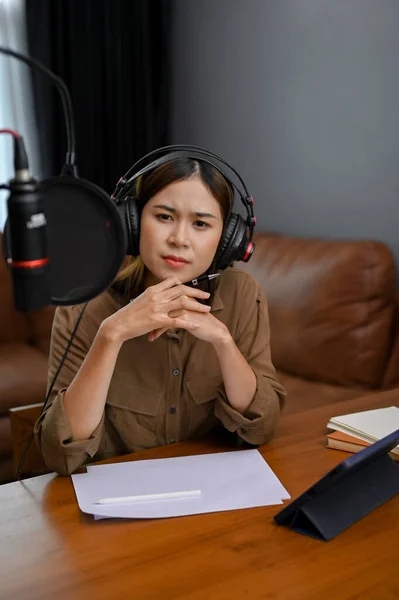 stock image Portrait, Professional Asian female radio host having a serious deep talk interview with her special guest in the studio. Broadcasting and podcasting concept.