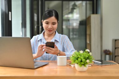 Güzel Asyalı genç iş kadını ya da ofis çalışanı masasında iş arkadaşlarıyla sohbet ediyor..