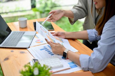 Kesilmiş çekim, iki profesyonel Asya finansal analisti veya bir mali raporu analiz eden ve gözden geçiren muhasebeci..